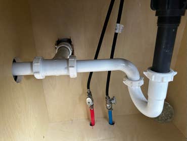 Photos by Des in the Cut Construction Company #1 We replaced a plastic, double-sink drain with pvc pipes, two P-traps and installed a vent so the water