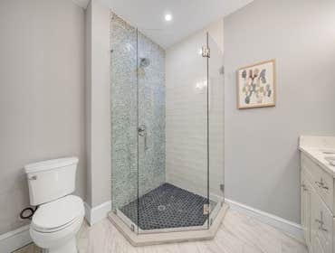 Photos by LCG BOSTON LLC #1 Full Home Remodel. Bathroom with custom glass, kitchen remodel with a beautiful exposed brick.