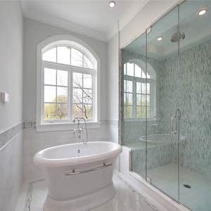 Bath White porcelain with glass tile. Shower features a bench and tray ceiling. Pedestal tub provides a timeless feel to the room.