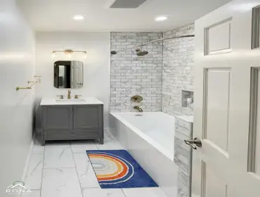 Burbank Bathroom Remodel Rona Home Remodeling created a timeless Burbank bathroom with a gray vanity, white quartz countertop, and brass fixtures. Whit