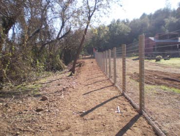 Fence Enclosure for Rescued Cats 850' of 6' high 2" x 4" fence with 5 gates. Project includes underground gopher wire along fence line to prevent coyo