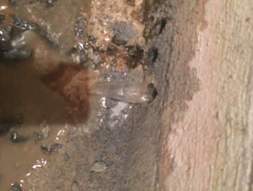Water pouring out of cinder block