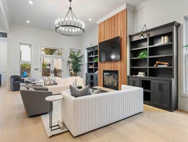 Great room with fluted fireplace wall and built-ins, open to pool patio; restoration and addition by CJMC Build in 12 South, Nashville.