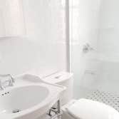 Upper West Side Our work for this project included full gut renovation with exposed brick wall, Calacatta countertop, and glass shower. Bathroom with c