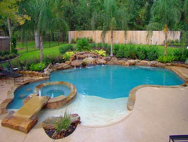 Fontenot Houston Pool Project Features on this Houston area custom pool design include: a large rectangle stone ledge to provide access from the deck 