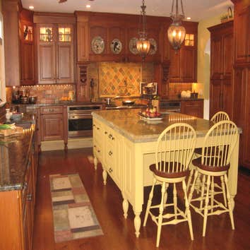 Mendham Kitchen Remodel This kitchen features a combination of cherry cabinetry, a yellow painted island and an antique green bar hutch. The custom c