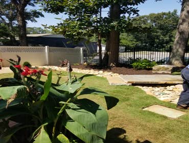 Wooded Court Yard A lovely home nestled on the edge of a wooded area has great location. Using lines of separation between lawn, wood and rock sections