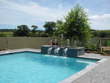 Infinity Edge swimming pool Charlottesville Infinity edge pool with colorized plaster, water feature, tanning shelf, seating benches w/ jets, beach ent