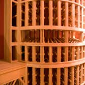 Project photos from Legacy Cellars Inc Custom African mahogany wine cellar within a room with a curved wall and sloping ceiling.