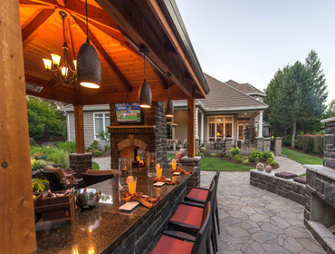 Photos by Paradise Restored Landscaping #1 Outdoor Living Space that includes a Covered Structure, Double Sided wood burning fireplace, Outdoor Kitchen