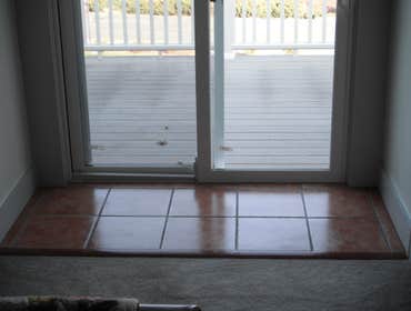 Stone House Remove cabinets and window, add wall closet to bedroom, install sliding door, tile on inside of slider, add secound story deck to front of 