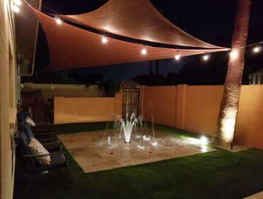 Custom Pools Wet edge pool in phoenix with sun shelf, splash pad and hardscape/landscape.