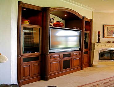 P S Woodworking Project Custom built-in arched Cherry media center with fluted columns and speakers integrated into doors & drawer fronts. Designed & h