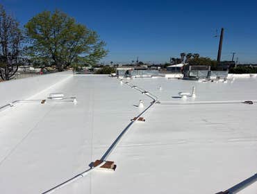 White 50 mil single-ply pvc IB Roof System with all conduit and condensation lines raised on blacks with separation sheets.