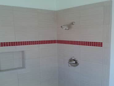 Guest bathroom shower and floor 12"x24" porcelain tile set on subway pattern with red glass mosaic liner
