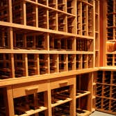 Project photos from Legacy Cellars Inc African mahogany wine cellar with curved upper wine racks.