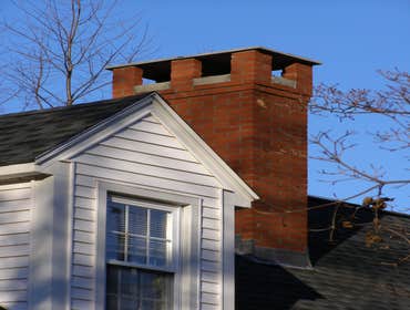 Chimney Rebuild with Raised Stone Cap, Amherst
In December 2011, Simmons Masonry rebuilt this chimney from just below the roofline up in Amherst. The