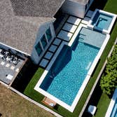 Prosper, TX This custom swimming pool in Prosper, TX proves that a narrow backyard can still deliver a true luxury outdoor living experience. The clean