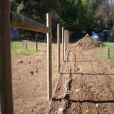 Fence Enclosure for Rescued Cats 850' of 6' high 2" x 4" fence with 5 gates. Project includes underground gopher wire along fence line to prevent coyo