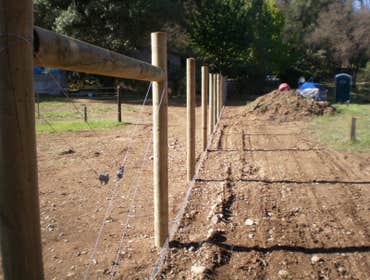 Fence Enclosure for Rescued Cats 850' of 6' high 2" x 4" fence with 5 gates. Project includes underground gopher wire along fence line to prevent coyo