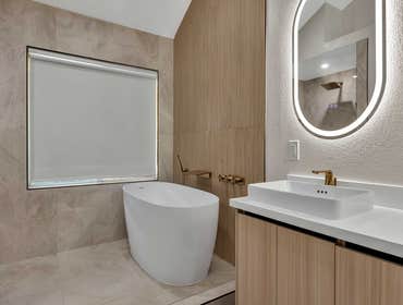 Bathroom Remodel | Pleasanton, CA Luxury bathroom remodel featuring a freestanding soaking tub, warm wood accents, elegant brass fixtures, and a modern