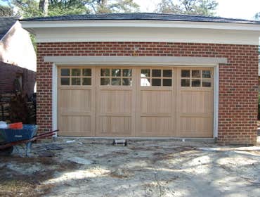 Carriage style doors First door (white with black hardware) is a stamped steel entry level door, second white painted custom door from Carriage House D