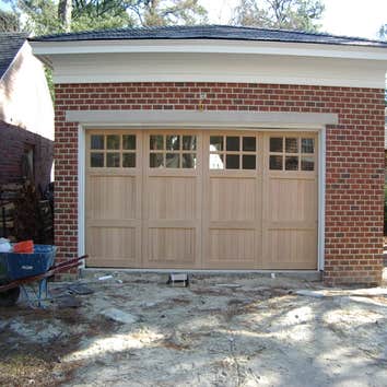 Carriage style doors First door (white with black hardware) is a stamped steel entry level door, second white painted custom door from Carriage House D