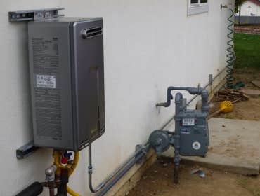 Tankless water heater installation Rinnai 9.4 tankless water heater, exterior installation on a slab foundation