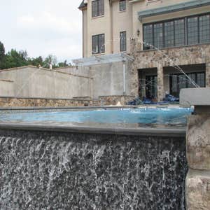 Infinity Edge swimming pool Charlottesville Infinity edge pool with colorized plaster, water feature, tanning shelf, seating benches w/ jets, beach...
