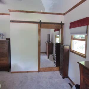 Photos by Banning Construction Inc #3 Knotty pine shelving with mirrored barn closet door.