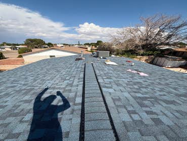Architectural shingle roof installation with clean vented ridge cap finish