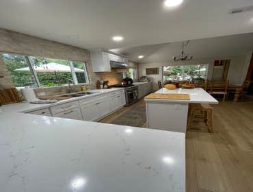 Photos by Lora Construction Services Inc #1 White shaker cabinetry Quartz countertop double bin trash cabinet drawer microwave refrigerator panels Thor