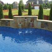 Clearwater Pools Cypress 18x36 Cypress with custom coping and retaining wall with waterfall in Hampton Cove, AL.