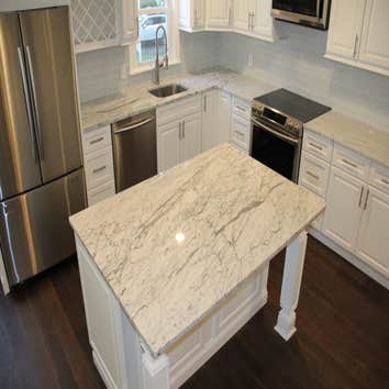 Kitchen Remodel Kitchen transformation including marble counter tops, custom white cabinets, dark stained natural hardwood flooring, glass tile back sp