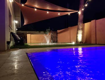 Custom Pools Wet edge pool in phoenix with sun shelf, splash pad and hardscape/landscape.