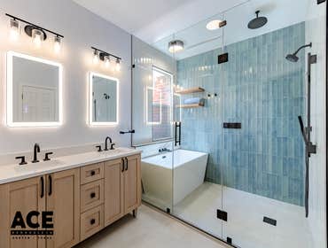 Bathroom Expansion This bathroom remodel transformed the space into a bright, modern retreat. The light wood vanity with matte black fixtures brings a 