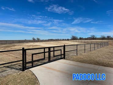 Photos by Paddco LLC #1 Total of 670 Ft top rail pipe fence with custom driveway gate and single walk through gate included.