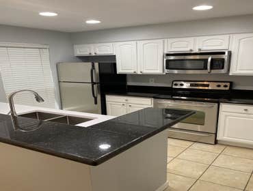 Remodeled kitchen showing stainless appliances and dark granite island