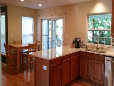 Kitchen remodel Removed breakfast nook wall and added flush steel beam in ceiling to open space. White quartz counters, cherry cabinets and glass tile 