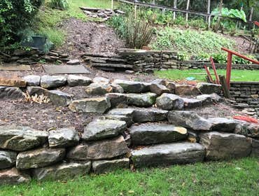 Wall Job in White Oak, PA Long natural boulder wall with 2 sets of stairs.