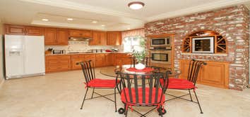Custom Kitchen/Sitting room Originally this kitchen and sitting room had outdated builders-grade tile countertops, stock cabinetry, old appliances, lam