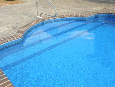 16x36 2' Radius Swimming Pool with Vinyl covered steps in S. huntsville, AL. Vinyl covered custom radius steps with brick coping in S. Huntsville, AL.