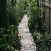 Landscape Design To maximize organic gardening space and extend the growing season in a narrow city lot, biota uses laser-cut Core-ten steel for raised