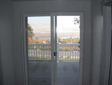 Stone House Remove cabinets and window, add wall closet to bedroom, install sliding door, tile on inside of slider, add secound story deck to front of 