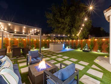 Flower Modern Backyard with BBQ & Firepit Immerse yourself in this beautifully designed modern backyard, featuring a cozy firepit surrounded by plush s