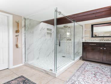 Meg | Bathroom This bathroom remodel features a fully upgraded shower with new tile, fixtures, and a custom glass enclosure, along with a stylish new s