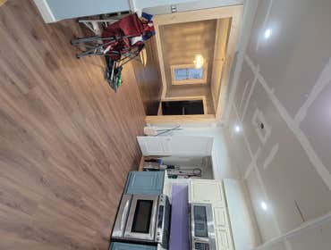 Kitchen remodel Removed load-bearing wall, drop ceiling, painted cabinets, installed laminate flooring, recessed lighting, new sink/waste disposal