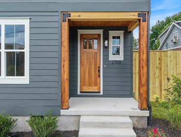 Warm wood front door with covered porch and timber accents at 2703 Bronte Ave, Nashville; built by CJMC Build.
