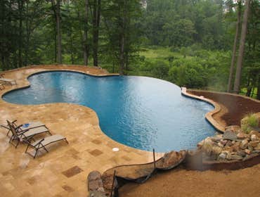 Infinity Edge swimming pool Charlottesville Infinity edge pool with colorized plaster, water feature, tanning shelf, seating benches w/ jets, beach ent
