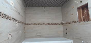 travertine stone shower, fish focils were cut into different sizes squares and inseted nin to the wall tiles, 4inch accent band, porcelain tile on celi